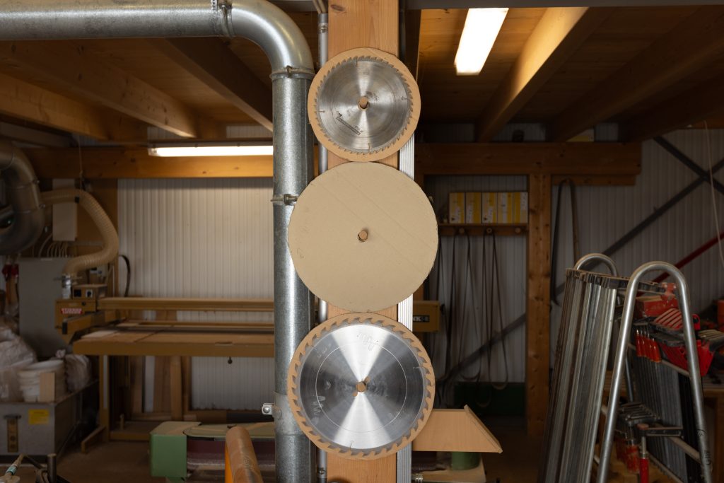 Das Bild zeigt einen Einblick in die Werkstatt: Holz und Sägeblätter, zufällig, aber sehr ästhetisch angeordnet.