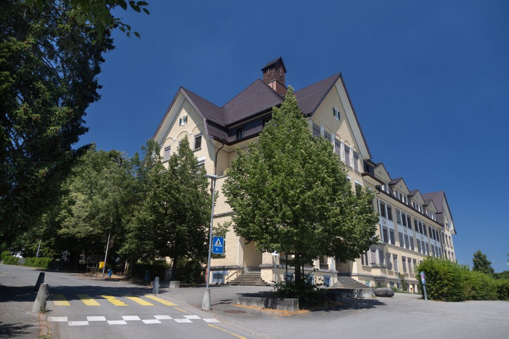Zu sehen ist das Schulhaus Rosenberg in Neuhausen in einer Grossaufnahme, an einem sonnigen Sommertag.