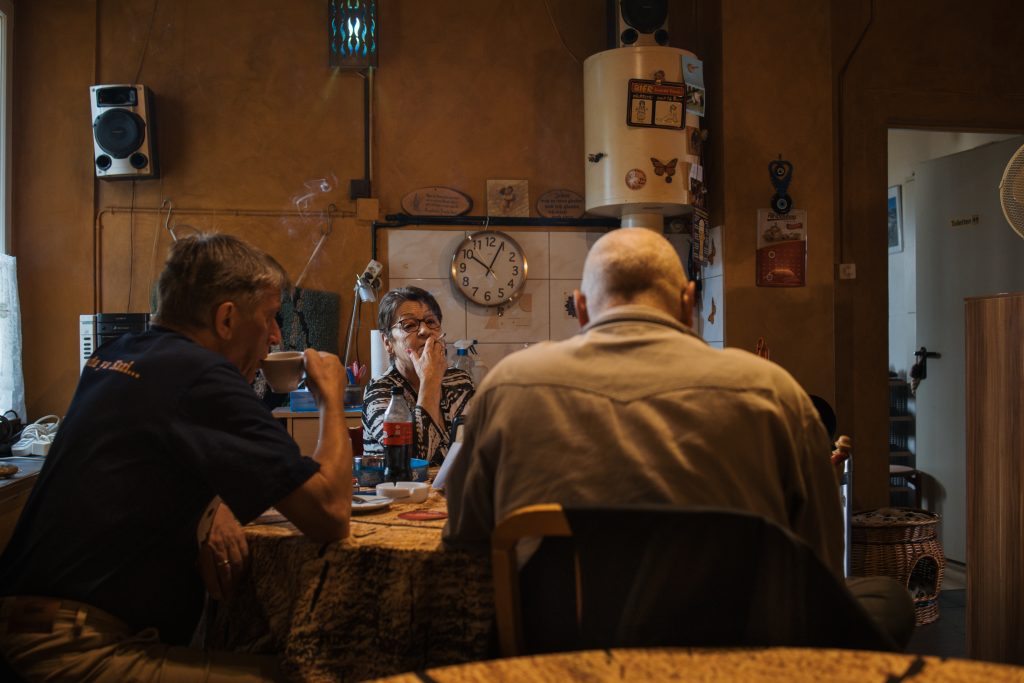 Rösli mit einer letzten Zigarette mit Stammgästen im Raucher-stübli. Fotos: Robin Kohler